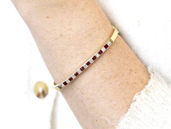 wearing ruby and diamond yellow gold bangle