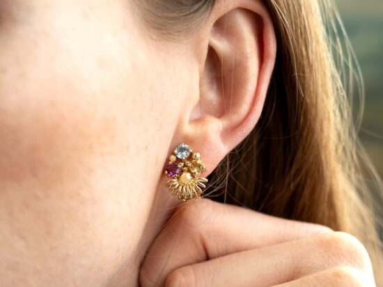 wearing gold gemstone earrings