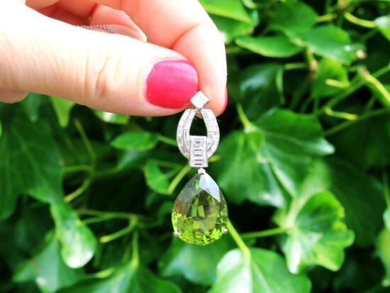 Pear shaped peridot pendant in platinum with diamonds outside