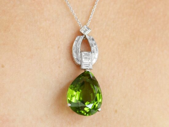 wearing Pear shaped peridot pendant in platinum with diamonds
