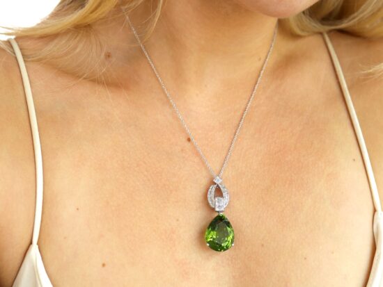 wearing Pear shaped peridot pendant in platinum with diamonds