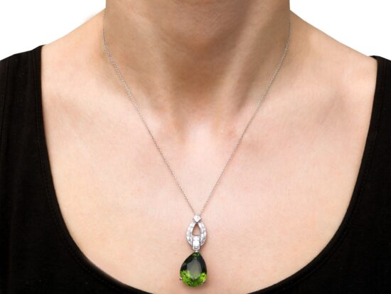 Pear shaped peridot pendant in platinum with diamonds wearing