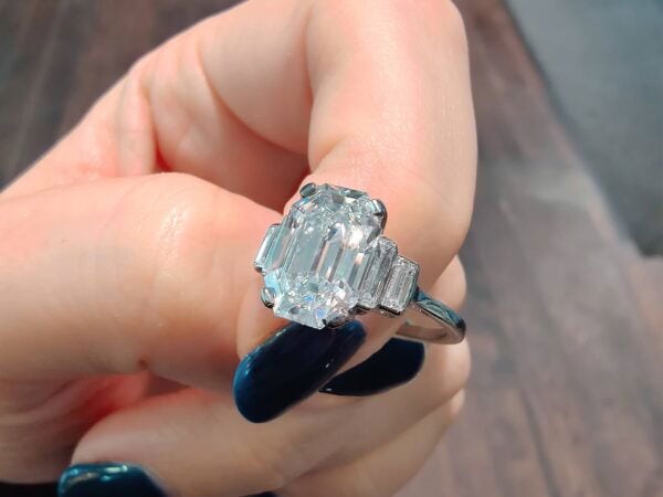 holding emerald cut diamond ring