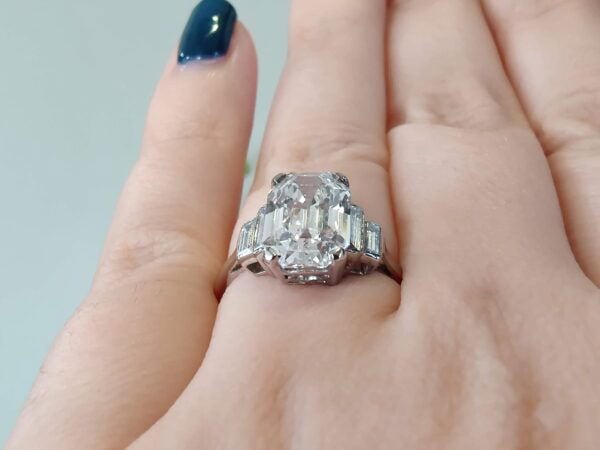 wearing emerald cut diamond ring in platinum on finger