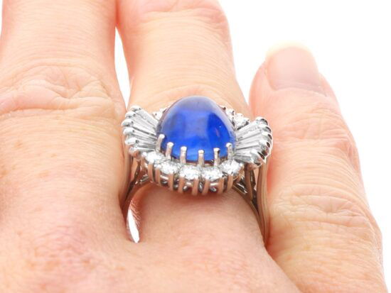 white gold oval sapphire ring on finger