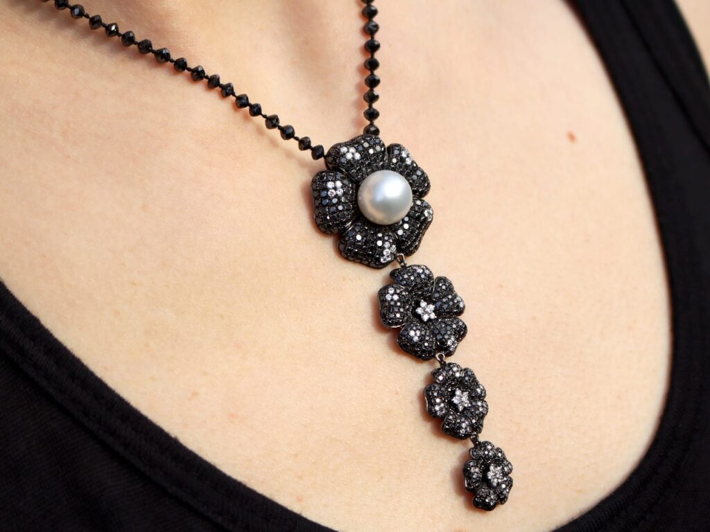 black diamond and pearl pendant on neck