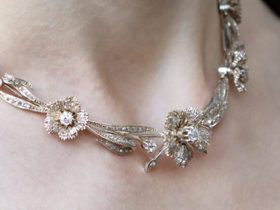 wearing a diamond floral necklace