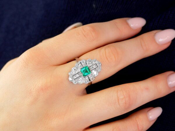 art deco emerald and diamond ring on hand