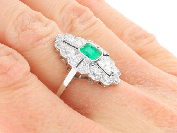 art deco emerald and diamond ring on hand