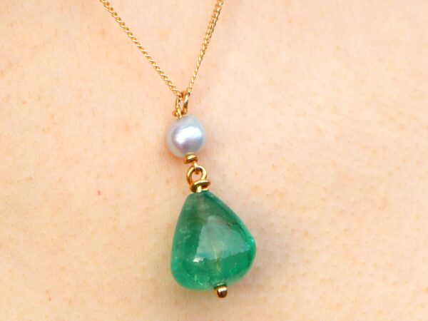 wearing GIA certified emerald pendant with pearl