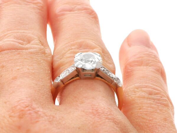 old European cut diamond solitaire ring in yellow gold on finger