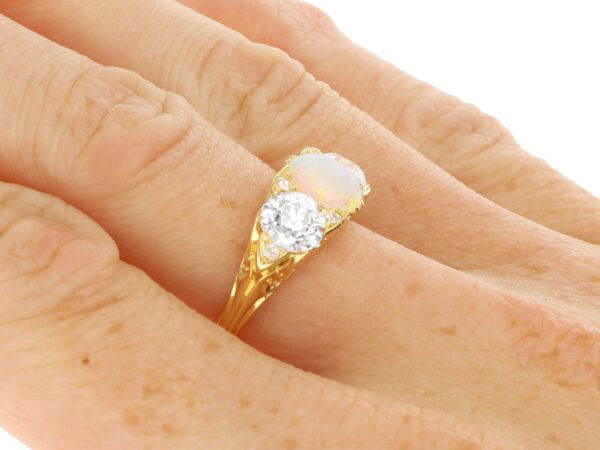 gold opal and diamond trilogy ring on finger