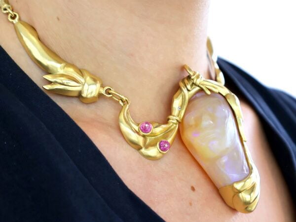 wearing gold carved opal and ruby necklace