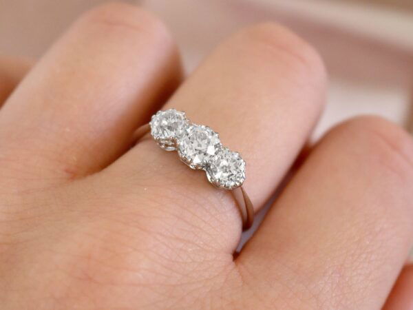 platinum 1920s three stone diamond ring on finger