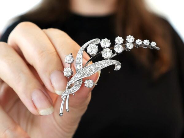 diamond floral brooch being held