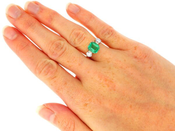 emerald trilogy engagement ring in gold on hand