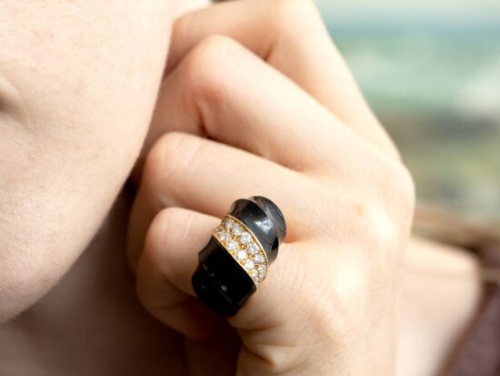 wearing a chunky onyx ring with diamonds