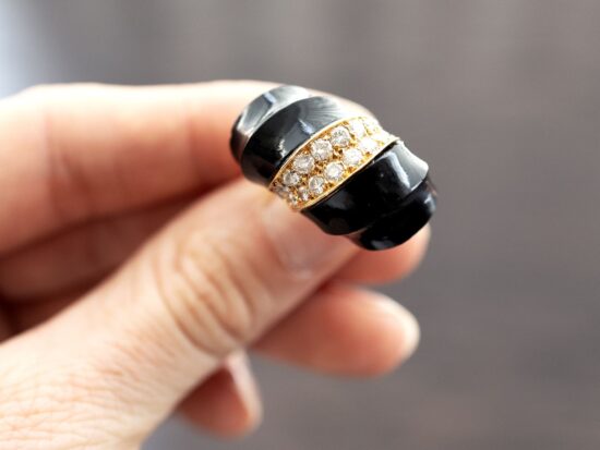 holding a chunky onyx ring in gold