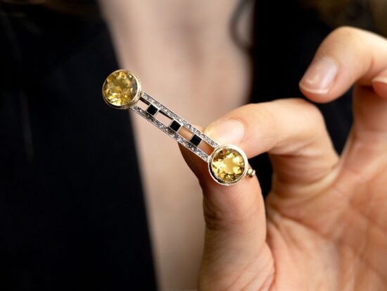 holding a citrine and onyx brooch