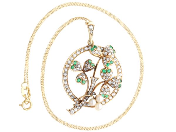 circular gold pendant with pearls and emeralds