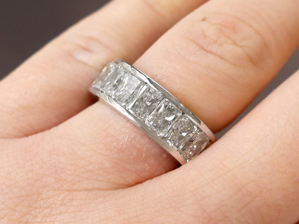 radiant cut diamond eternity ring on finger